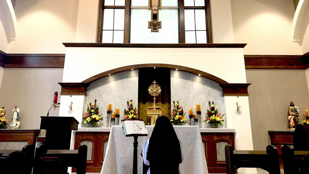 Sister praying in front of the altar